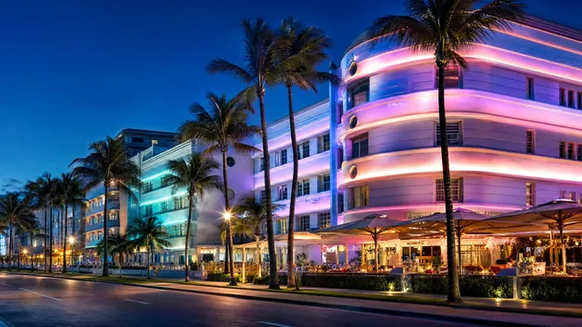 Art Deco hotels at blue hour, their neon glowing.