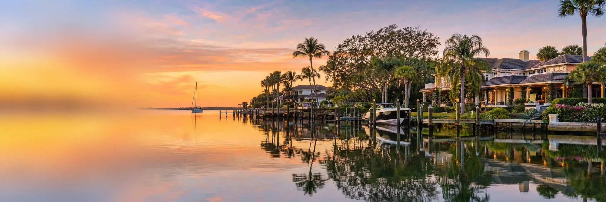 Sunset on the St. Lucie River, waterfront homes along the bank.